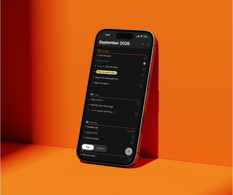 kata dark mode on an iPhone leaning against an orange wall